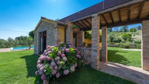 A stone building with a pool, surrounded by lush greenery and a clear blue sky. - An-f453-cbgn2at - Casale Verdicchio (Montecarotto)