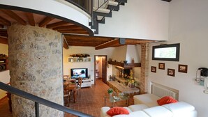 A spacious living area with a fireplace, a dining area, and a staircase leading to an upper level. - Si-i877-sp3714at - La Capanna di Franca 6 2 (Sovicille)