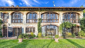Un edificio grande e histórico con múltiples ventanales de arco y fachada de piedra.
