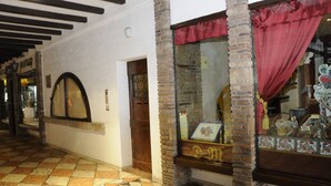 A corridor with a tiled floor, a door with a wooden frame, and a window with a red curtain. - Bs-i633-viem71a1 - Arcimboldo House 2 2 (Sirmione)
