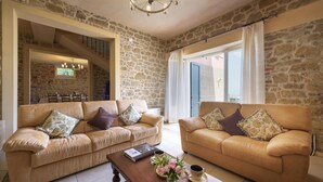 A spacious living room with two leather sofas, a coffee table, and a dining area visible through an open door. - Ar-a291-loto0at - Villa Vittoria d Anghiari 7 3 (Anghiari)