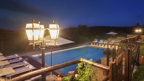 A swimming pool with lounge chairs and umbrellas, surrounded by a wooden fence and a stone wall. - Ar-a291-loto0at - Villa Vittoria d Anghiari 7 3 (Anghiari)