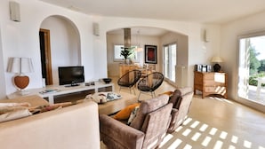 A modern living room with a sofa, TV, and dining area. - Le-c336-sp2140bt - Villa Pajare Francesi 8 2 (Castrignano del Capo)