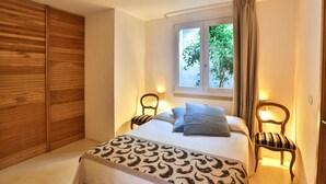 A bedroom with a bed, two bedside tables, a window with curtains, a wooden wardrobe, and a patterned throw on the bed. - Le-c336-sp2140bt - Villa Pajare Francesi 8 2 (Castrignano del Capo)