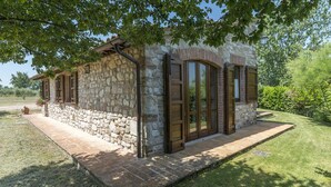 A stone building with a brick pathway, large windows, and a well-maintained lawn. - Tr-i381-vena0at - Casale al Doglio 6 1 (San Venanzo)