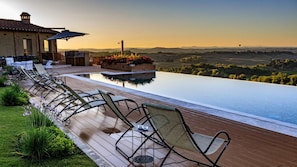 Area piscina con lettini e vista sulla campagna.