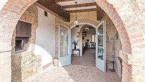 An interior with arched brick walls, a central open space, and a dining area in the background. - Il Colle Di Donna Ilaria 16 (Buonconvento)