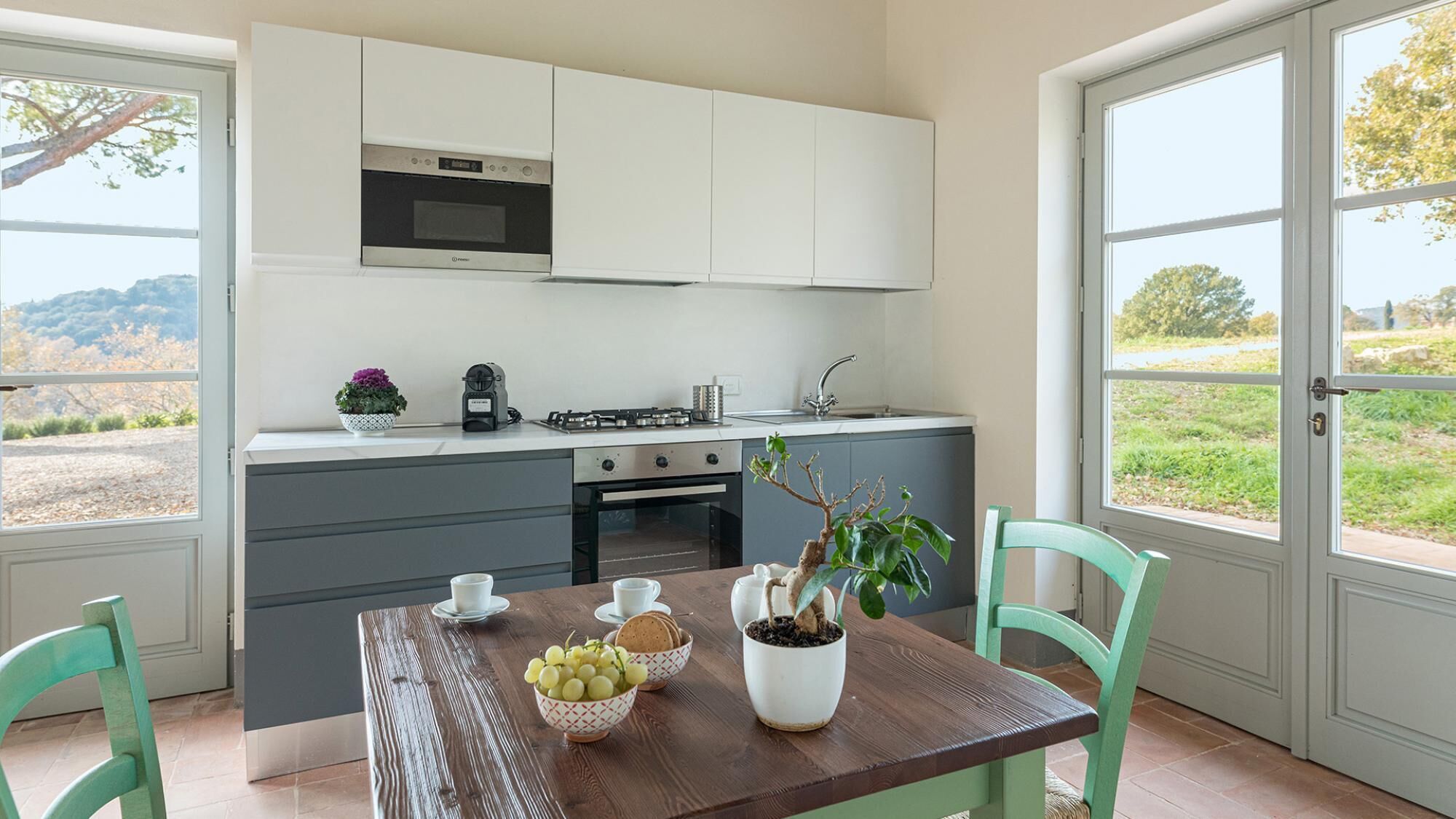 Une cuisine dotée d’un îlot central, d’une cuisinière et d’un évier. Une fenêtre offre une vue sur l’extérieur.