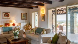 A cozy living room with a fireplace, a coffee table, and a view of the outdoors. - Villino Bruna 6 in Bertinoro (Bertinoro)