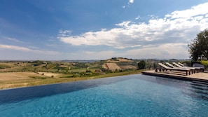 An infinity pool with a view of rolling hills and vineyards.