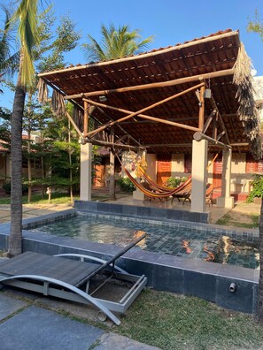 A pool area with a hammock, a covered seating area, and a small pool. - Mar de Jeri (Jijoca de Jericoacoara)