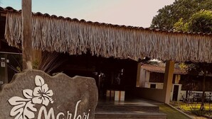 A rustic building with a thatched roof and a sign reading "Marjori de".