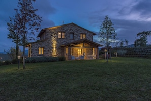 A stone house with a covered porch and outdoor seating area.