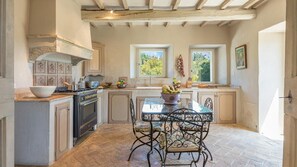 Enjoy cooking in this well-equipped kitchen with a central island, stove, sink, and cabinets.