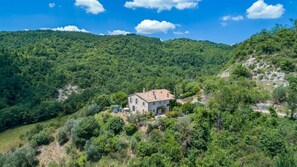 Escape to a serene valley retreat surrounded by lush greenery and forested hills.