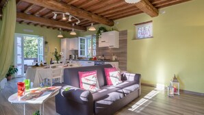 A cozy living area with a sofa, a dining table, and a kitchen in the background. - Ai Due Cuori 4 2 in Capannori (Capannori)