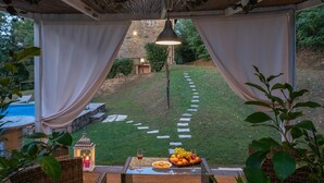 A covered outdoor seating area with a stone pathway leading to a stone building. - Ai Due Cuori 4 2 in Capannori (Capannori)