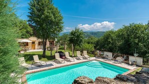 Un espace piscine avec des chaises longues et une vue sur les montagnes.