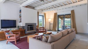 A modern living room with a fireplace, a television, and a sofa. - Villa Le Fontane 12 (Todi)
