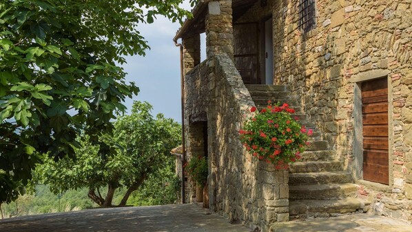 A rustic stone building with a wooden door and a small window.
