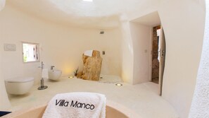 Ein Badezimmer mit einem weißen Waschbecken, einer Toilette, einer Badewanne und einem Handtuch mit dem Schriftzug "Villa Manco".