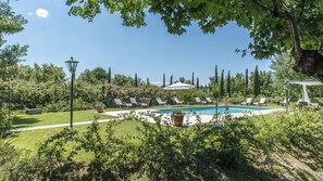 A pool area with lounge chairs and a pergola. - Albachiara 8 in Cortona (Cortona)