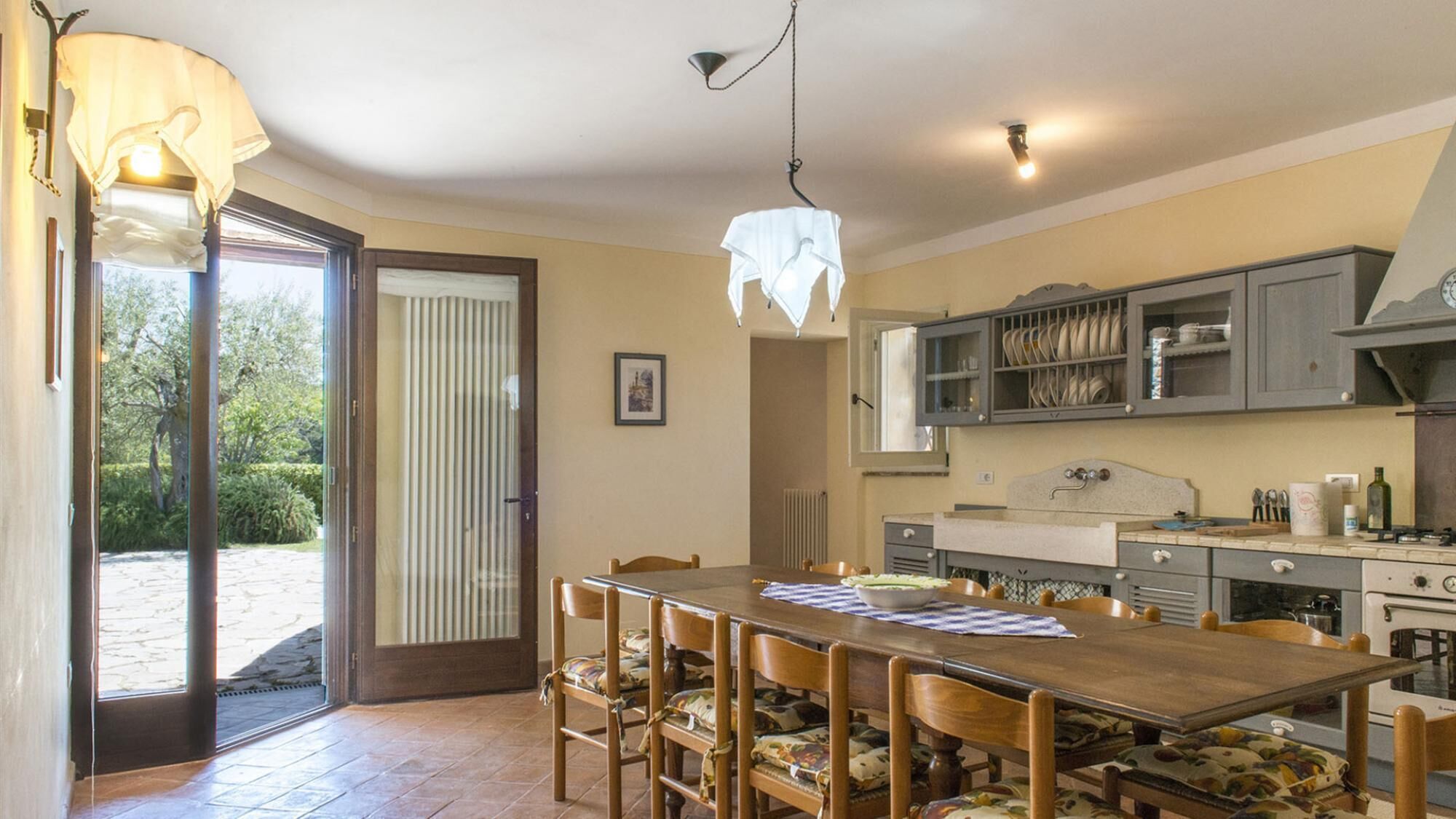 A kitchen with a wooden table and chairs, a stove, and a sink.
