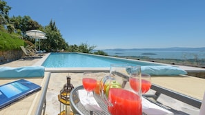 Vista de la piscina con una computadora portátil, bebidas y una botella.