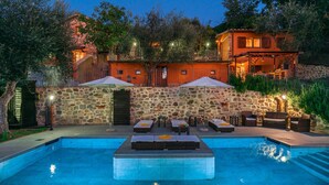 A swimming pool with lounge chairs and umbrellas, surrounded by stone walls and trees. - Casale Montegiovi 6 4 (Castel del Piano)