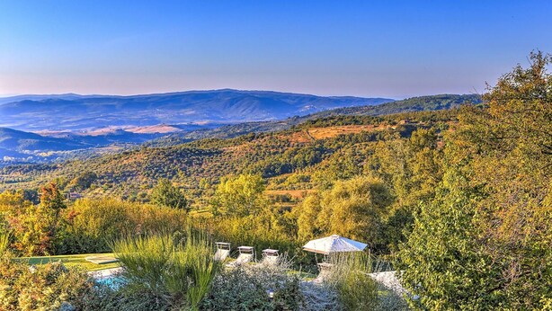 A mountainous landscape with a view of distant hills and a small building with a white roof in the foreground. - Casale Le Conce 6 (Castel del Piano)
