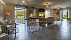 Une cuisine moderne avec des carreaux hexagonaux, un coin bar avec des tabourets et des luminaires suspendus.