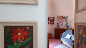 Ein Zimmer mit einem Bett, einem Schminktisch und einem Blumenbild.