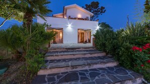 A modern two-story house with stone steps leading to the entrance, surrounded by lush greenery and a clear evening sky. - Ripari Di Giobbe 6 2 (Ortona)