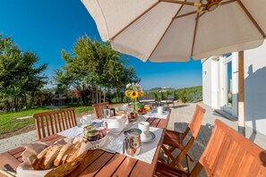 Enjoy a meal al fresco with a beautifully set table amidst lush surroundings.