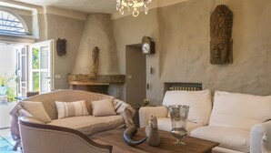 A cozy living room with a sofa, a coffee table, and a fireplace. - Il Castellaccio 8 in Brisighella (Brisighella)