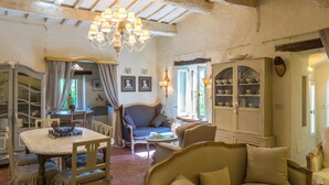 A cozy room with a dining table, chairs, a sofa, and a cabinet with dishes. - Il Castellaccio 8 in Brisighella (Brisighella)
