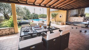 An outdoor patio area with a dining table set for breakfast, surrounded by wicker furniture. - Il Giardino Dei Limoni 8 (Ispica)