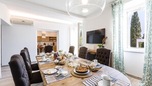Un espace repas moderne avec une table en bois dressée pour le repas, entourée de sièges confortables.