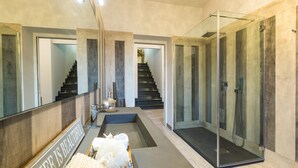 Une salle de bain moderne dotée d’une douche à parois de verre, d’un banc intégré et d’un grand miroir.