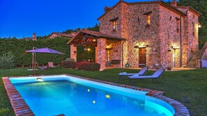 A stone house with a swimming pool, lounge chairs, and a patio umbrella. - San Rocco 4 in Montecchio (Montecchio)