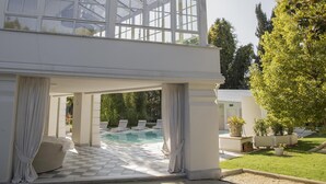 A modern house with a pool area, outdoor seating, and a well-maintained garden. - Villa La Perla Bianca 10 (Empoli)