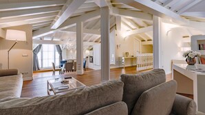 A spacious loft apartment with high ceilings, exposed beams, and a modern kitchen. - Villa La Perla Bianca 10 (Empoli)