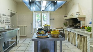 A modern kitchen with stainless steel appliances, a central island with food items, and a built-in oven. - Villa La Corte 6 in Montecastrilli (Montecastrilli)