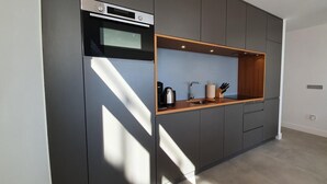 Eine moderne Küche mit Einbauofen, Kaffeemaschine und Messerblock.
