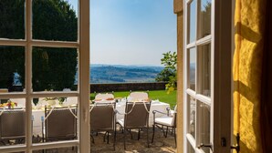 An open patio with a table set for breakfast, overlooking a scenic landscape. - Tenuta Di Pratello 24 (Peccioli)