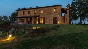 A stone building with a large arched entrance and a covered patio area.