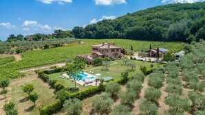Un vaste domaine comprenant une piscine, un vignoble et plusieurs bâtiments.