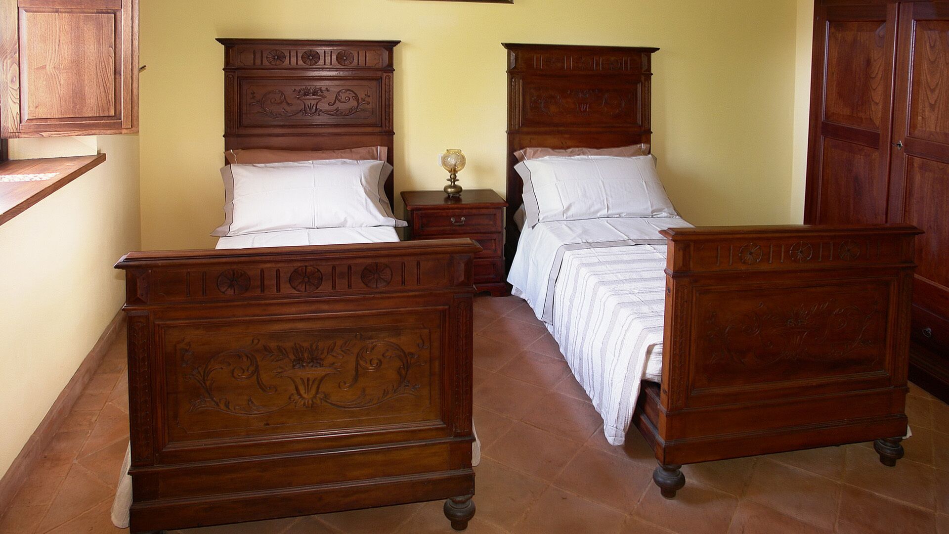 Une chambre à coucher avec deux lits en bois, une table de chevet et une commode.
