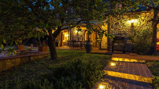 An outdoor patio area with stone walls, a grill, and a seating arrangement. - Villa Santa Maria 14 (Castelnuovo Berardenga)