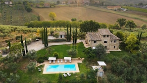 A stone villa with a swimming pool, surrounded by lush greenery and vineyards. - Villa Di Morice 12 in Castel Ritaldi (Castel Ritaldi)